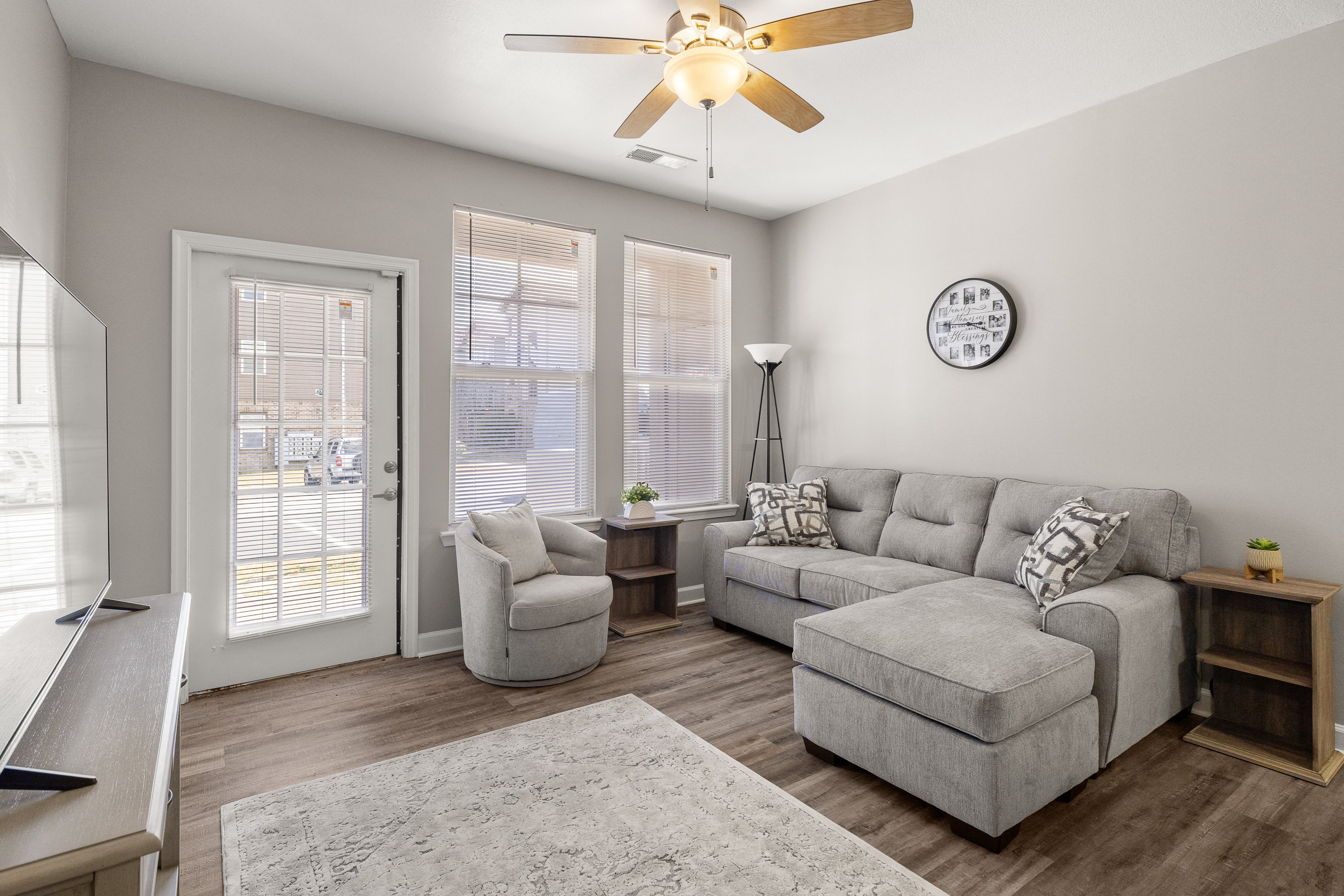 a living room with a couch and a chair and a ceiling fan